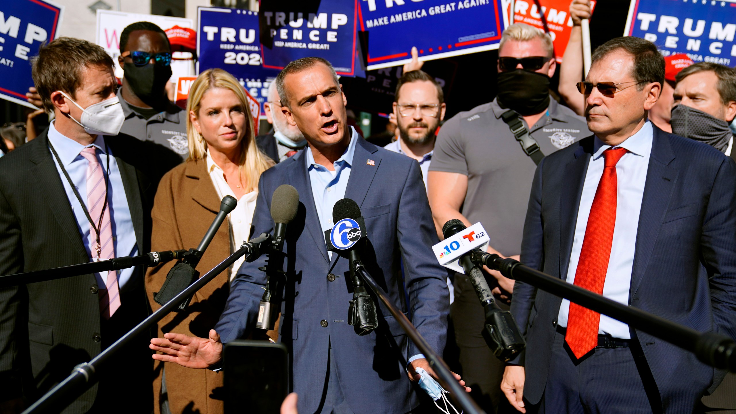 President Donald Trump's campaign advisor Corey Lewandowski, center, speaks outside the Pennsylvania Convention Center where votes are being counted, Thursday, Nov. 5, 2020, in Philadelphia, following Tuesday's election. At left is former Florida Attorney General Pam Bondi. (AP Photo/Matt Slocum)