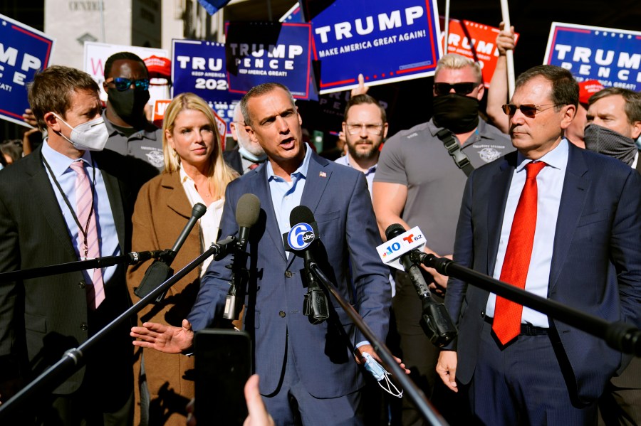 President Donald Trump's campaign advisor Corey Lewandowski, center, speaks outside the Pennsylvania Convention Center where votes are being counted, Thursday, Nov. 5, 2020, in Philadelphia, following Tuesday's election. At left is former Florida Attorney General Pam Bondi. (AP Photo/Matt Slocum)