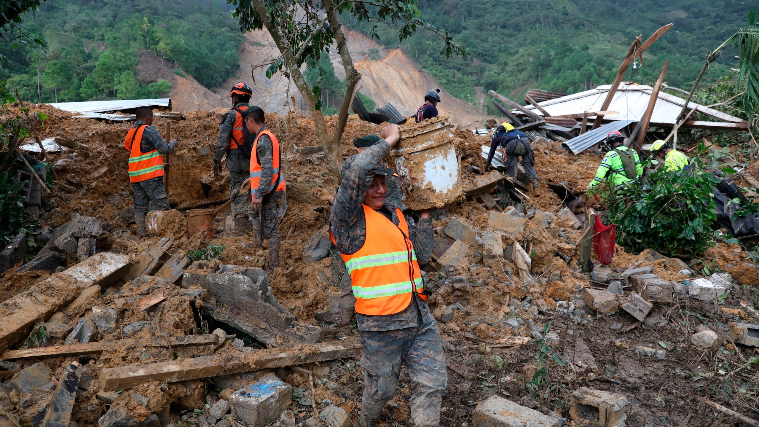 Members of search and recovery teams search for survivors in the debris of a massive, rain-fueled landslide in the village of Queja, in Guatemala, Saturday, Nov. 7, 2020, in the aftermath of Tropical Storm Eta. (Esteban Biba/Pool Photo via AP)