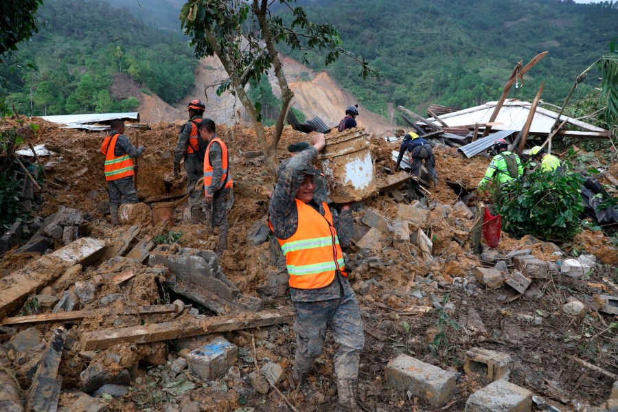 Members of search and recovery teams search for survivors in the debris of a massive, rain-fueled landslide in the village of Queja, in Guatemala, Saturday, Nov. 7, 2020, in the aftermath of Tropical Storm Eta. (Esteban Biba/Pool Photo via AP)