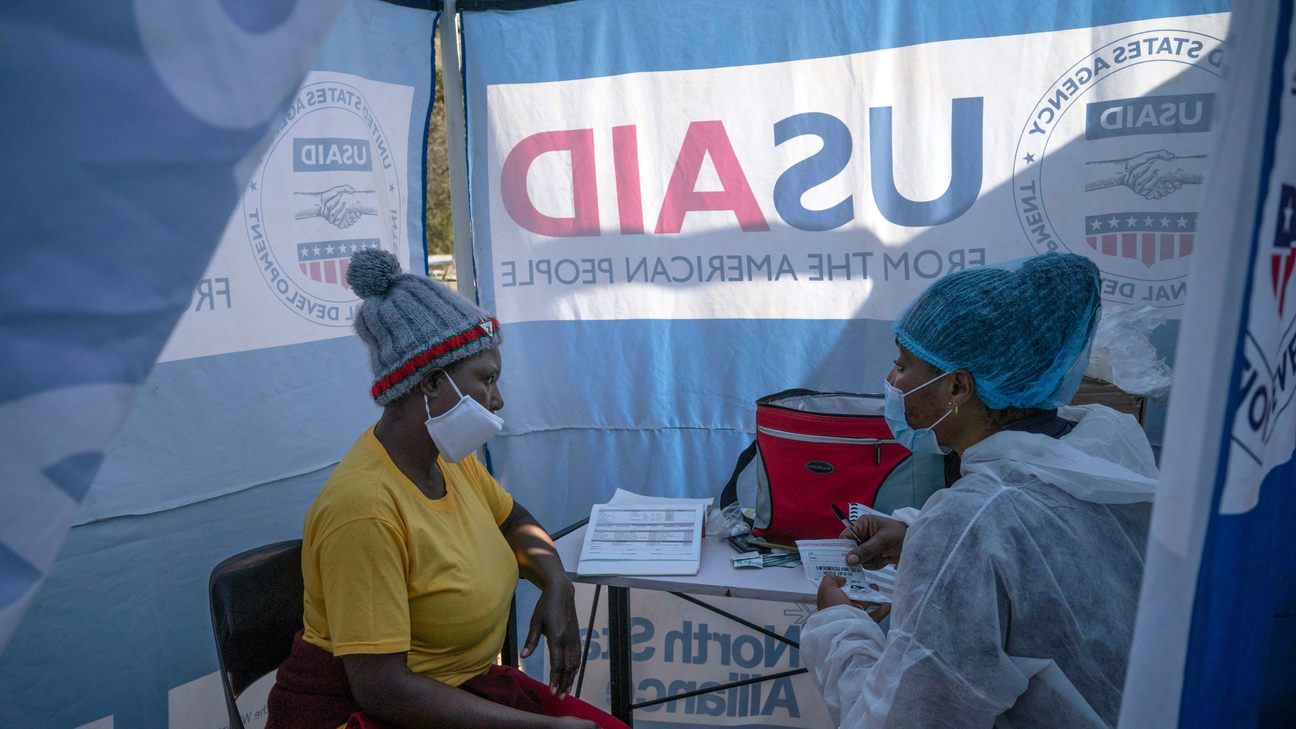 In this July 2, 2020 file photo, nurse Nomautanda Siduna, right, talks to a patient who is HIV-positive inside a gazebo used as a mobile clinic in Ngodwana, South Africa. Researchers are stopping a study early after finding that a shot of an experimental medicine every two months worked better than daily Truvada pills to help keep uninfected women from catching HIV from an infected sex partner. The news is a boon for AIDS prevention efforts especially in Africa, where the study took place, and where women have few discreet ways of protecting themselves from infection. (AP Photo/Bram Janssen, File)