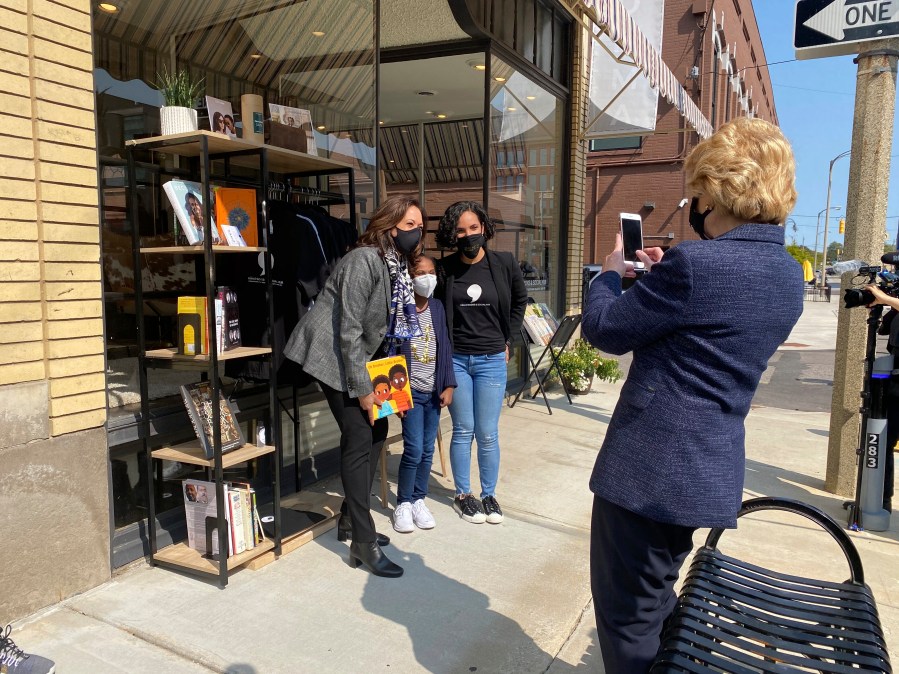 Michigan Sen. Debbie Stabenow, right, takes a picture of Vice President-elect Kamala Harris posing for a photo on Sept. 22, 2020 with Egypt Otis and her nine-year-old daughter Eva Allen in front of their downtown Flint, Mich., bookstore, the Comma Bookstore & Social Hub. (AP Photo/Katrease Stafford)