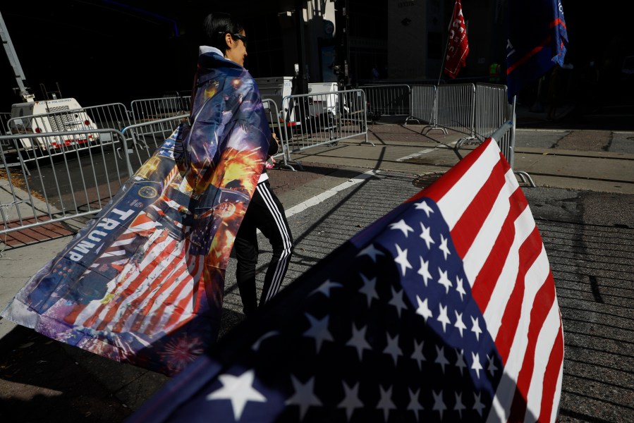 A woman wears a Trump flag as a cape as supporters of President Donald Trump protest outside the Pennsylvania Convention Center, where vote counting continues, in Philadelphia, on Nov. 9, 2020, two days after the 2020 election was called for Democrat Joe Biden. (Rebecca Blackwell / Associated Press)