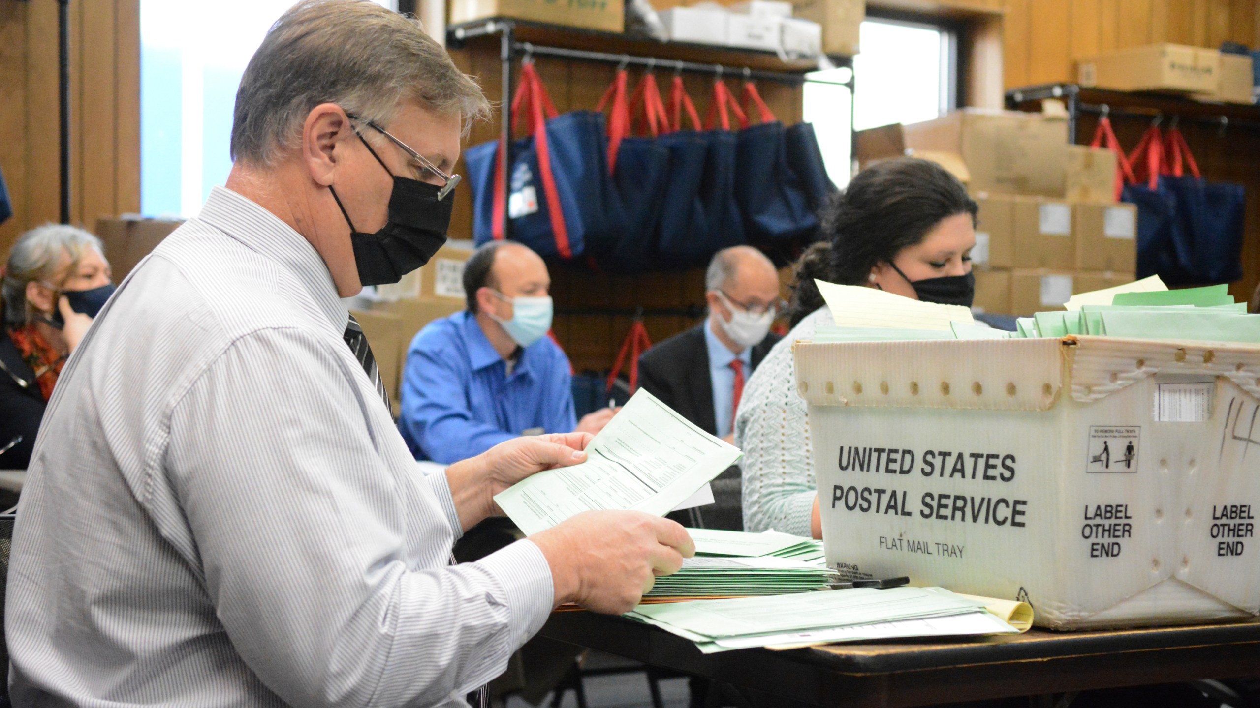 Election Bureau Director Albert L. Gricoski, left, opens provisional ballots alongside election bureau staff Christine Marmas, right, while poll watchers observe from behind at the Schuylkill County Election Bureau in Pottsville, Pa. on Tuesday, Nov. 10, 2020. (Lindsey Shuey/The Republican-Herald via AP)