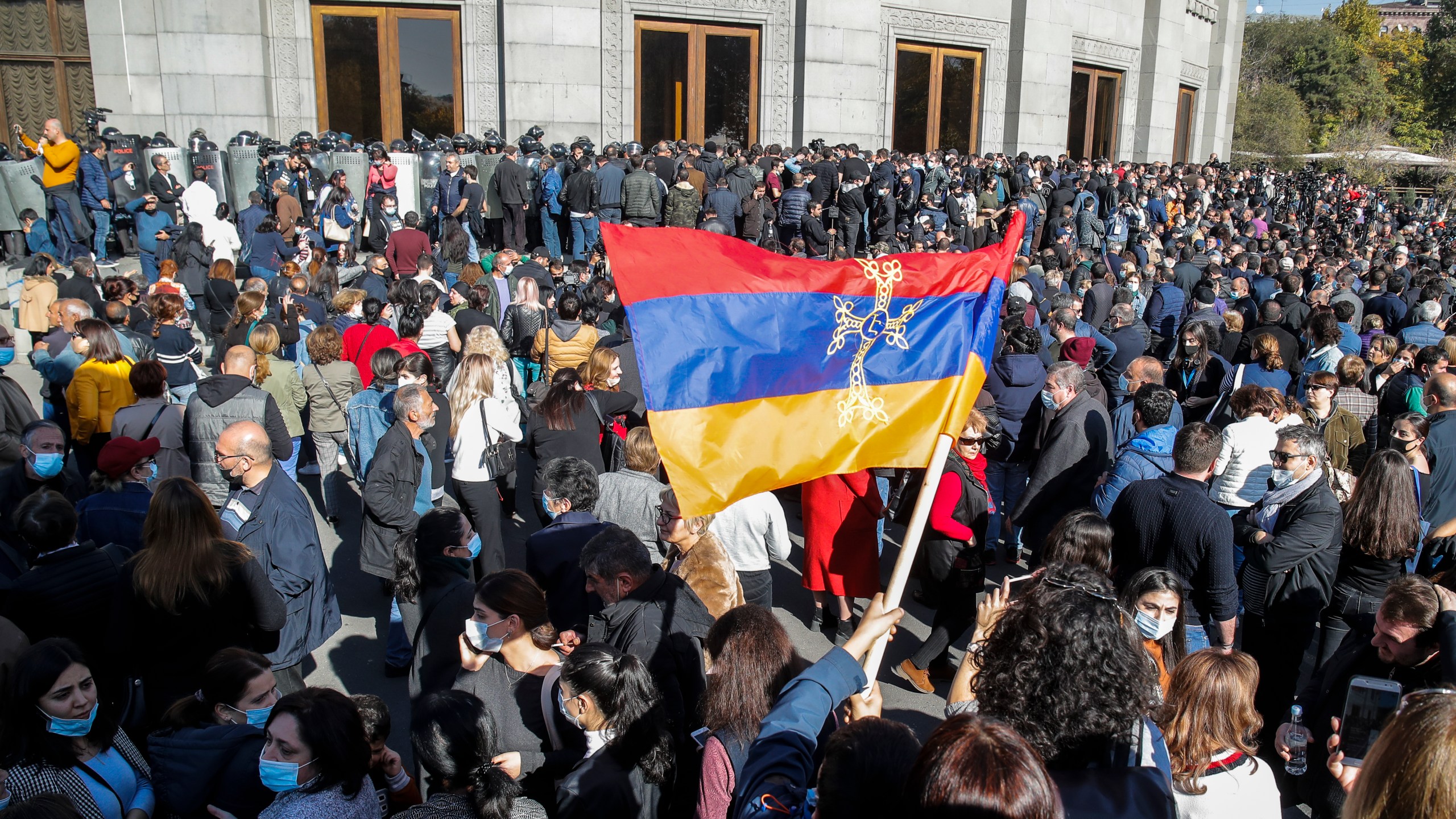 Protesters wave an Armenian national flag during a protest against an agreement to halt fighting over the Nagorno-Karabakh region, in Yerevan, Armenia, Wednesday, Nov. 11, 2020. (AP Photo/Dmitri Lovetsky)