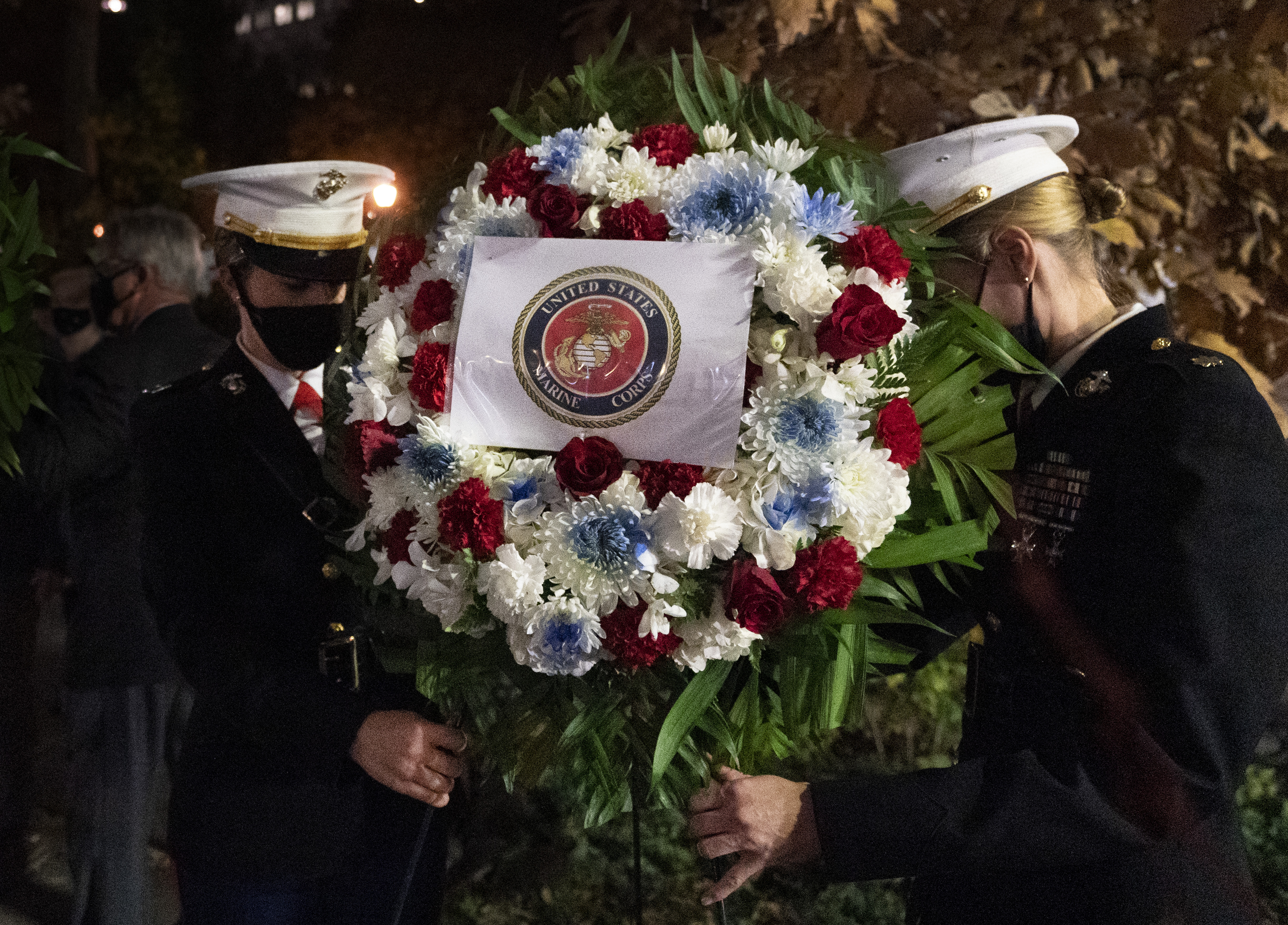 A Navy and Marine Corps honor guard lays a wreath at the Eternal Light Flagstaff in Madison Square Park, Wednesday, Nov. 11, 2020 in New York. The ceremony preceded a quiet 100-vehicle Veterans Day parade, with no spectators, to maintain the 101-year tradition of veterans marching on Fifth Avenue. (AP Photo/Mark Lennihan)