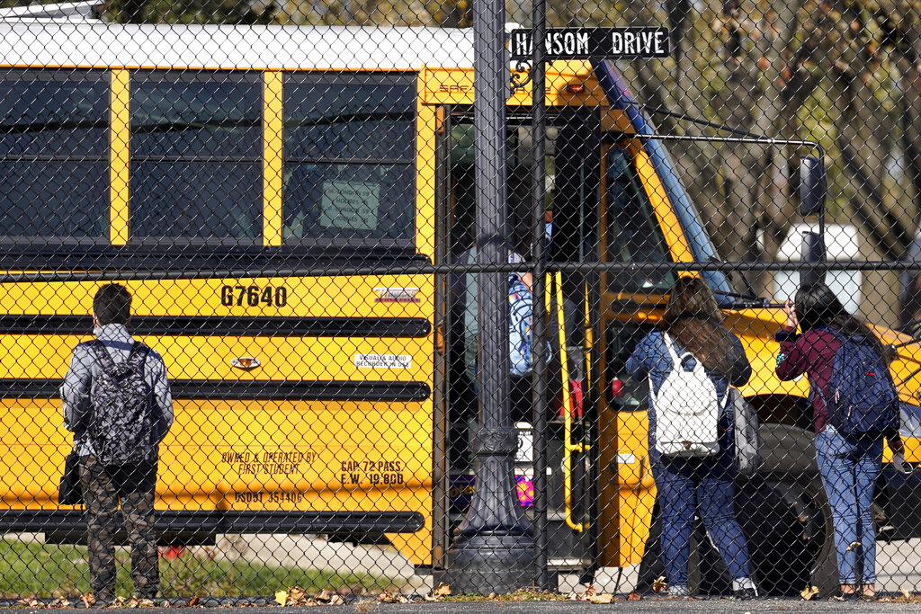 In this Friday, Nov. 6, 2020 file photo, students wait to board a school bus in Wheeling, Ill. (AP Photo/Nam Y. Huh)