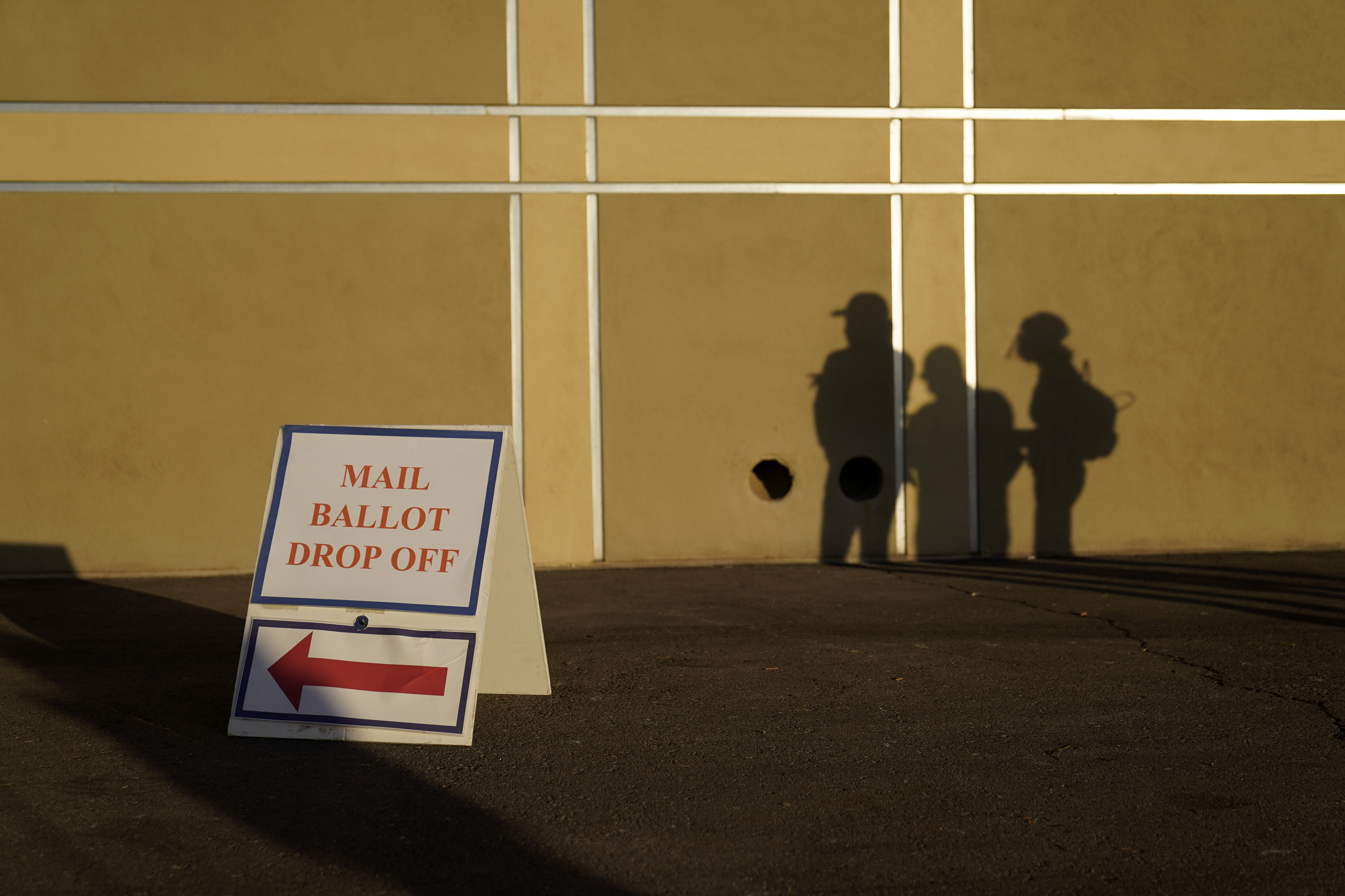 In this Nov. 3, 2020, file photo people wait outside of a polling place on Election Day in Las Vegas. Nevada election law stipulates that in order to register to vote, an individual must have been a resident for 30 days preceding an election, but does not specify how long an already registered voter must be physically present in the state in order to participate in an election. (AP Photo/John Locher, File)