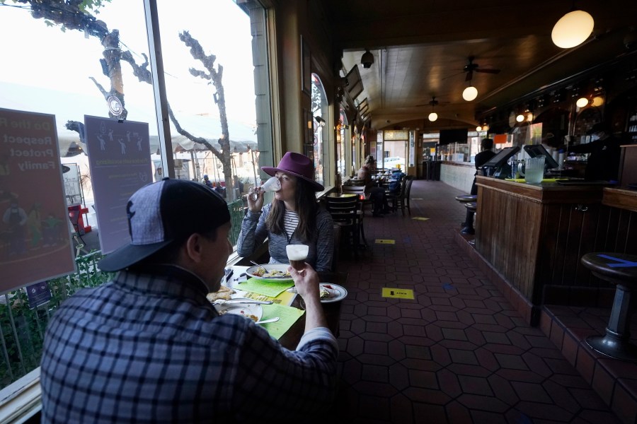 Mitchell Bryant, left, and Darla Scott eat inside at the Buena Vista Cafe in San Francisco during the coronavirus outbreak on Nov. 12, 2020. (Jeff Chiu / Associated Press)