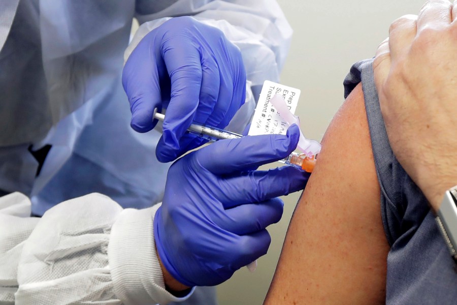 In this Monday, March 16, 2020 file photo, Neal Browning receives a shot in the first-stage safety study clinical trial of a potential vaccine for COVID-19, the disease caused by the new coronavirus at the Kaiser Permanente Washington Health Research Institute in Seattle. (Ted S. Warren/AP Photo)