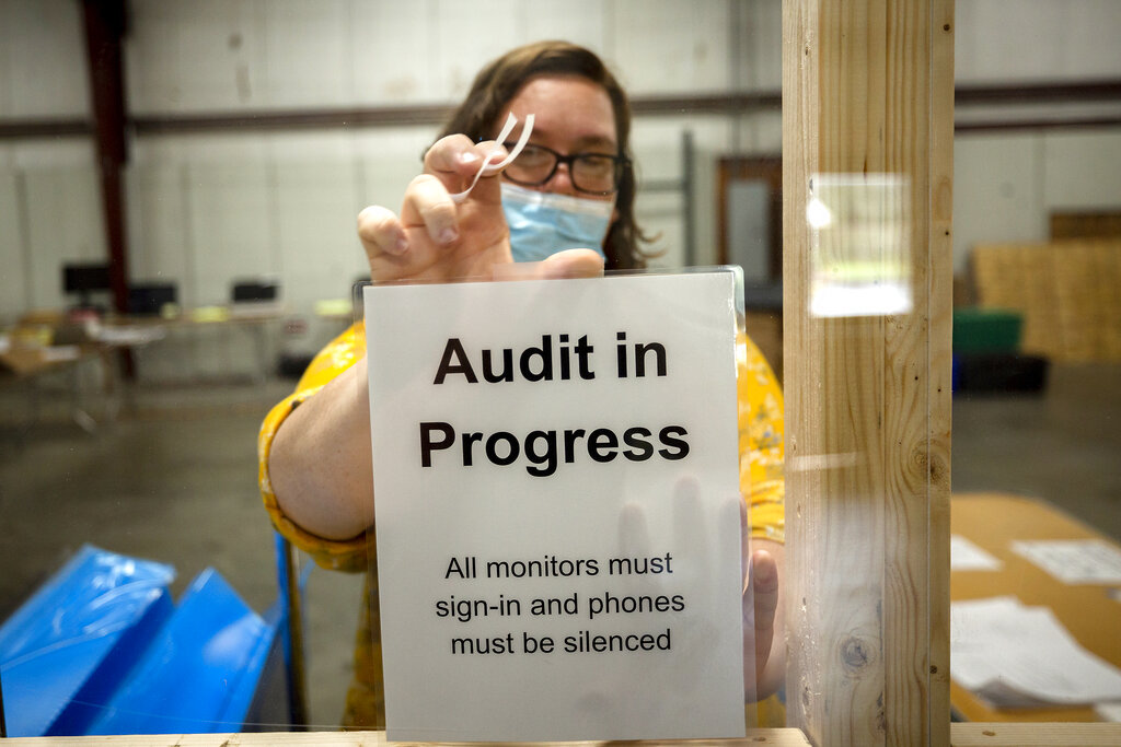 A Chatham County election official posts a sign in the public viewing area before the start of a ballot audit, Friday, Nov. 13, 2020, in Savannah, Ga. (AP Photo/Stephen B. Morton)