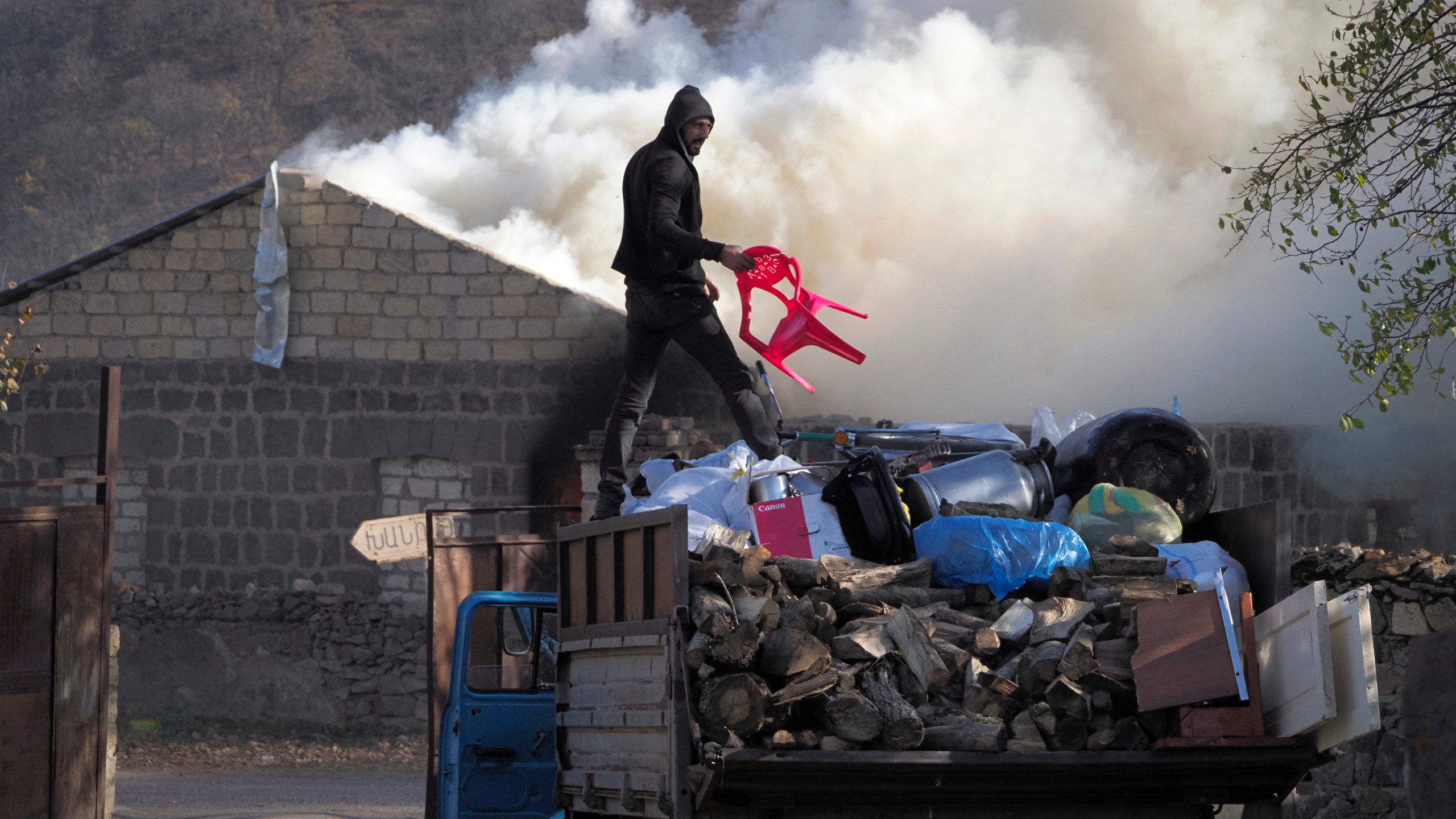 A man loads possessions on his truck after setting his home on fire, in an area once occupied by Armenian forces but is soon to be turned over to Azerbaijan, in Karvachar, the separatist region of Nagorno-Karabakh, on Friday, Nov. 13, 2020. (Dmitry Lovetsky/AP Photo)