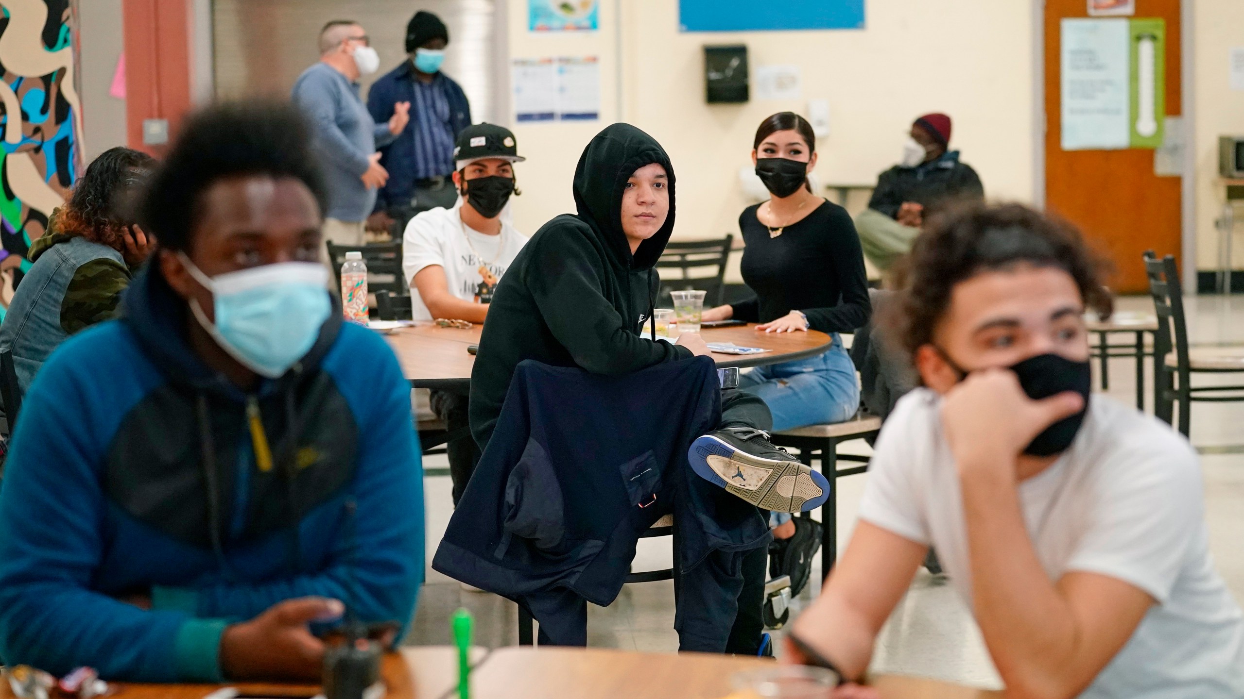 In this Oct. 29, 2020, file photo, students at West Brooklyn Community High School listen to questions posed by their principal during a current events-trivia quiz and pizza party in the school's cafeteria in New York. (AP Photo/Kathy Willen, File)