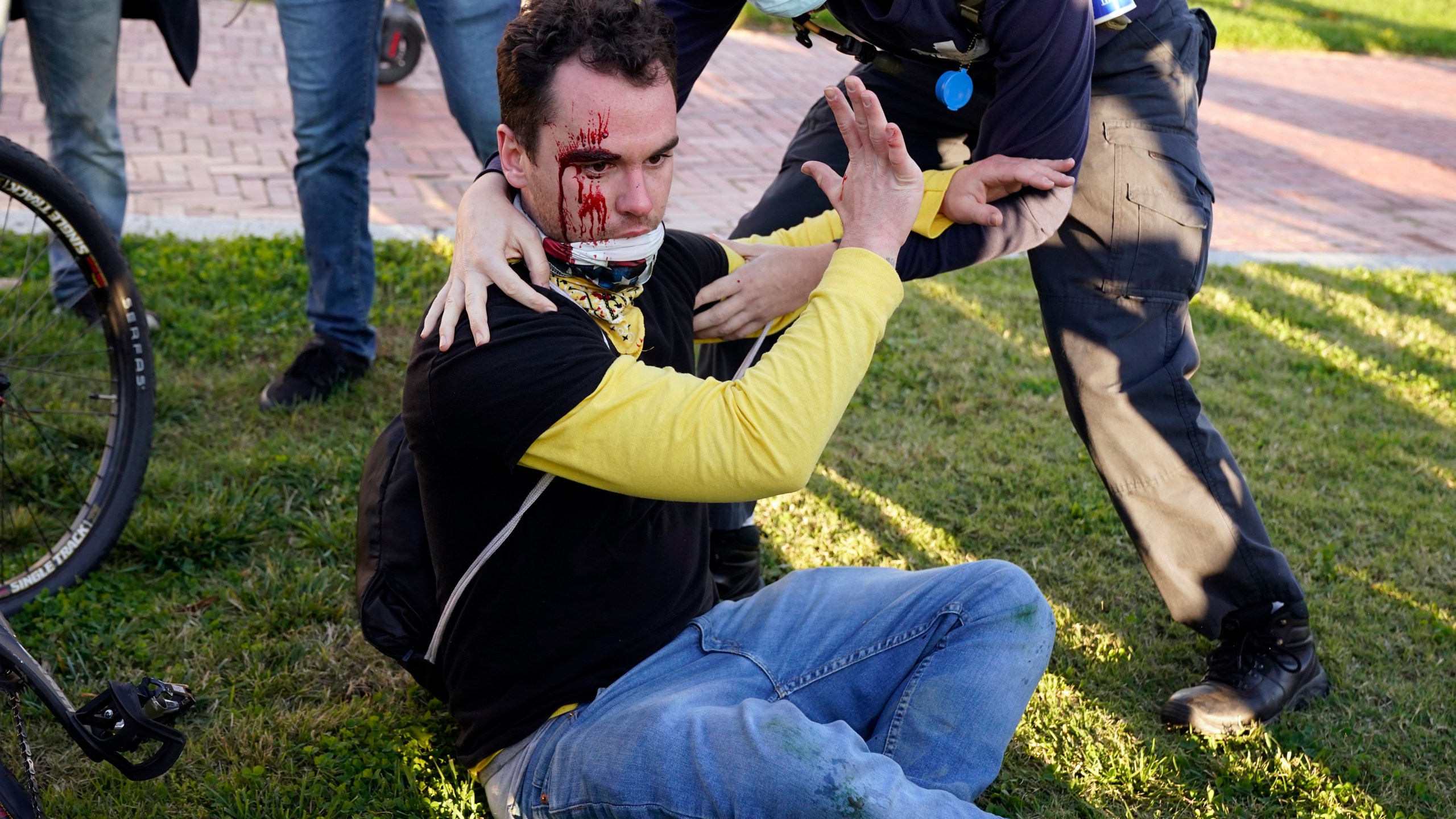 A counter-protester helps a supporter of President Donald Trump who was injured after he was attacked during a pro-Trump rally on Nov. 14, 2020, in Washington. (AP Photo/Jacquelyn Martin)