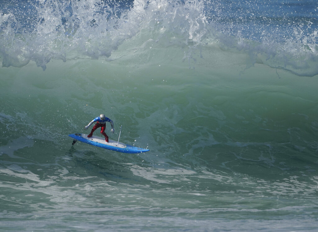 A remote-controlled RC surfer model rides a wave in Huntington Beach, Calif., Sunday, Nov. 15, 2020. (AP Photo/Damian Dovarganes)