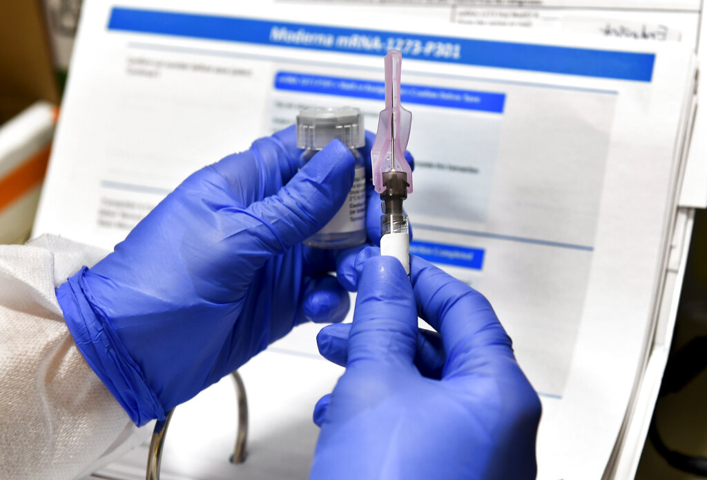 In this July 27, 2020, file photo, nurse Kathe Olmstead prepares a shot that is part of a possible COVID-19 vaccine, developed by the National Institutes of Health and Moderna Inc., in Binghamton, N.Y. (AP Photo/Hans Pennink, File)