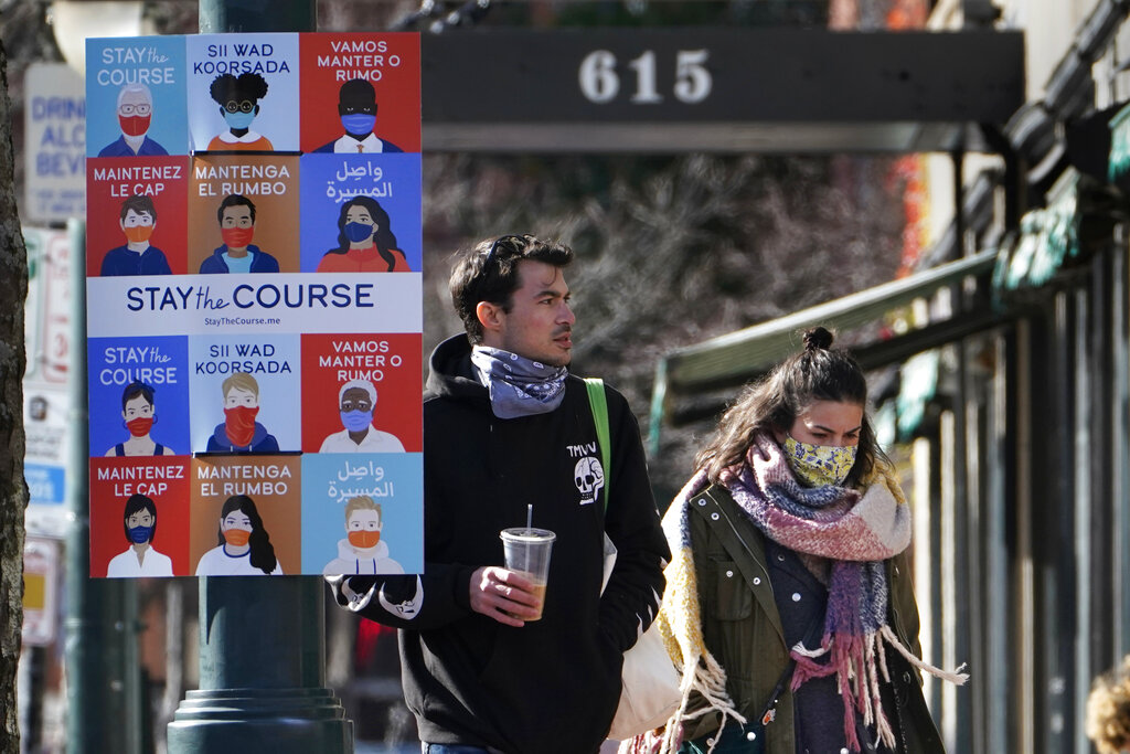 A sign in multiple languages encourages citizens to wear face coverings to help prevent the spread of COVID-19, Tuesday, Nov. 17, 2020, in Portland, Maine. (AP Photo/Robert F. Bukaty)