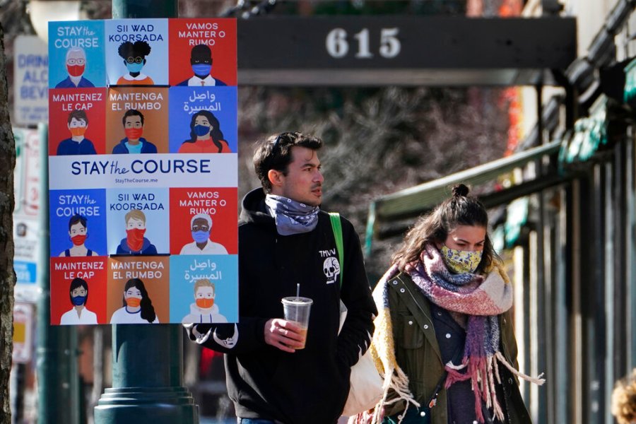 A sign in multiple languages encourages citizens to wear face coverings to help prevent the spread of COVID-19, Tuesday, Nov. 17, 2020, in Portland, Maine. (AP Photo/Robert F. Bukaty)