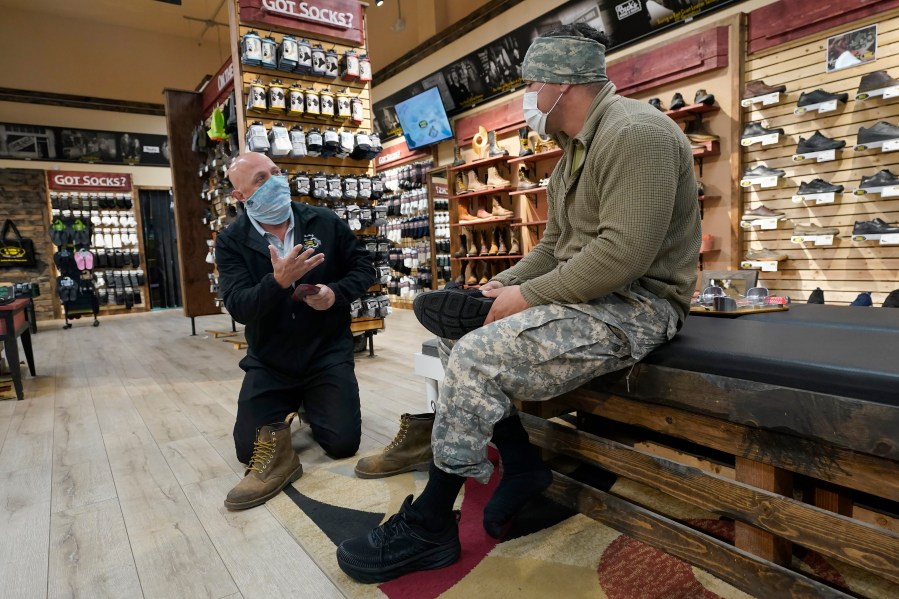 Patrick Marks, left, helps customer Jesus Chavez at Beck's Shoes in the Sutter County committee of Yuba City, Calif., on Nov. 17, 2020. (Rich Pedroncelli / Associated Press)