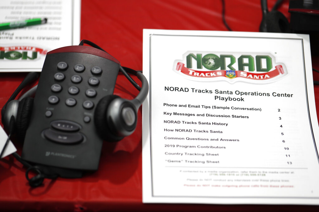 In this Dec. 23, 2019, file photo a playbook sits next to a telephone set up in the NORAD Tracks Santa center at Peterson Air Force Base in Colorado Springs, Colo. (AP Photo/David Zalubowski, File)