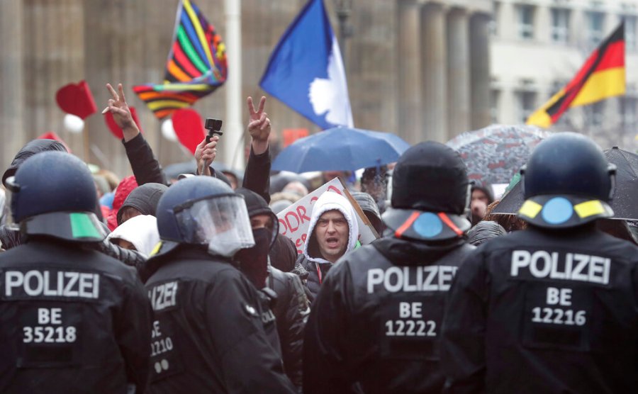 A protestor shouts as people attend a protest rally in front of the Brandenburg Gate in Berlin, Germany, Wednesday, Nov. 18, 2020 against the coronavirus restrictions in Germany. (AP Photo/Michael Sohn)