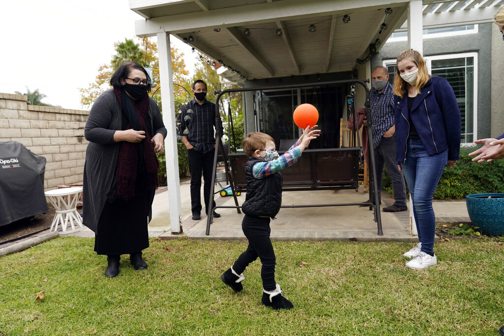 The Schmidt family, from, left, Heather Schmidt, her husband Nicholas Philbrook, son Andrew, 4, father Raymond and daughter Ava are seen in their backyard on Nov. 18, 2020, in Camarillo, Calif. Philbrook and his wife have been trying to convince court officials that he should be excused from jury duty because her father, a cancer survivor with diabetes, lives with them. But court officials told him that is not a valid reason and he must appear in court in early December. (AP Photo/Marcio Jose Sanchez)