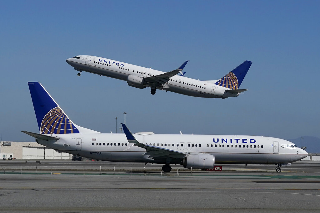 In this Oct. 15, 2020, file photo, a United Airlines airplane takes off over a plane on the runway at San Francisco International Airport. (Jeff Chiu/AP Photo)