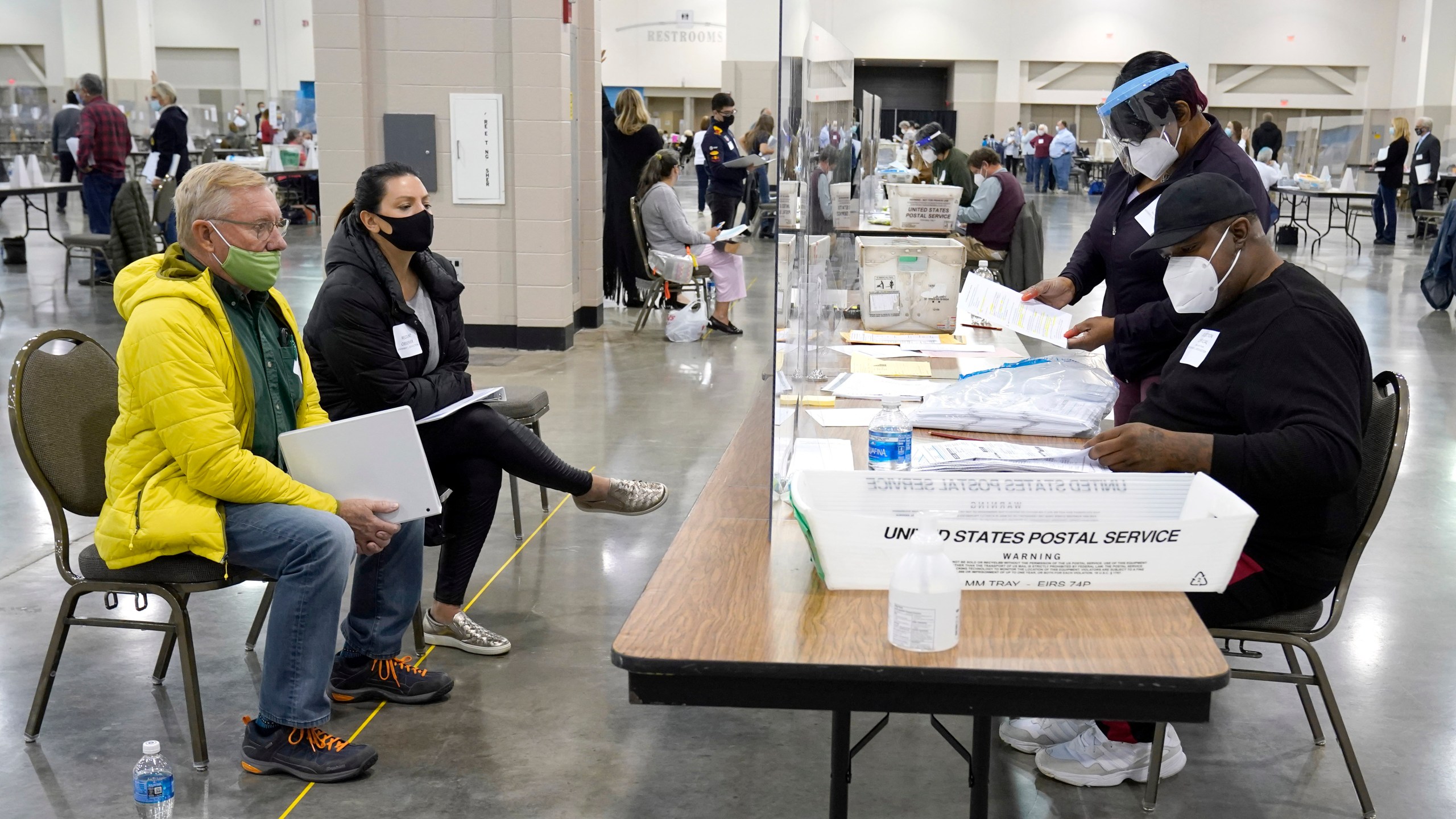 Election workers, right, verify ballots as recount observers, left, watch during a Milwaukee hand recount of presidential votes at the Wisconsin Center, Friday, Nov. 20, 2020, in Milwaukee. (AP Photo/Nam Y. Huh)