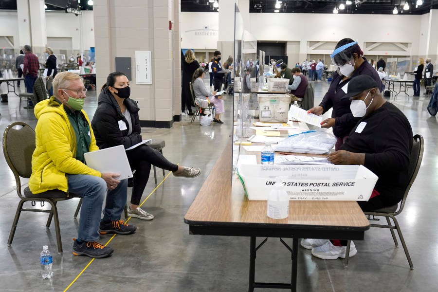 Election workers, right, verify ballots as recount observers, left, watch during a Milwaukee hand recount of presidential votes at the Wisconsin Center, Friday, Nov. 20, 2020, in Milwaukee. (AP Photo/Nam Y. Huh)