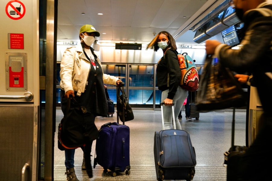 Travelers leave the AirTrain at JKF International Airport Friday, Nov. 20, 2020, in New York. (AP Photo/Frank Franklin II)