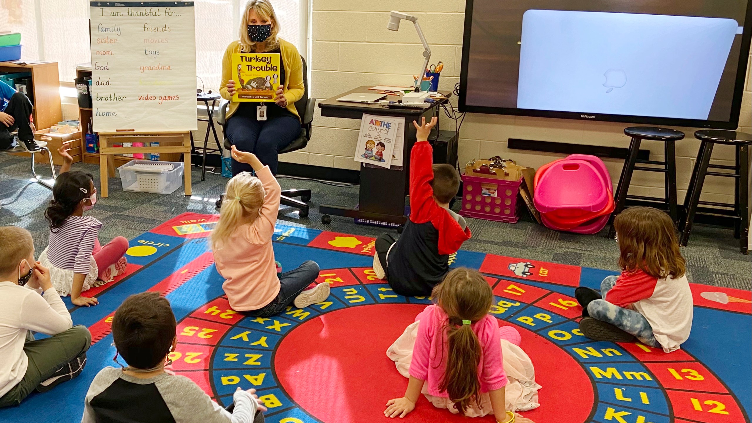 In this photo provided by Julie Mackett, the kindergarten teacher conducts her class at Ft. Meigs Elementary School, in Perrysburg, Ohio. Contact tracing and isolation protocols meant to contain the spread of the coronavirus are sidelining school employees and frustrating efforts to continue in-person learning. “I think everybody understands when you can’t have enough subs to fill the roles, it’s also a safety issue: You can’t have that many children without support from adults,” said Mackett, who went through her own two-week quarantine early in the school year after a student tested positive. (Courtesy of Julie Mackett via AP)