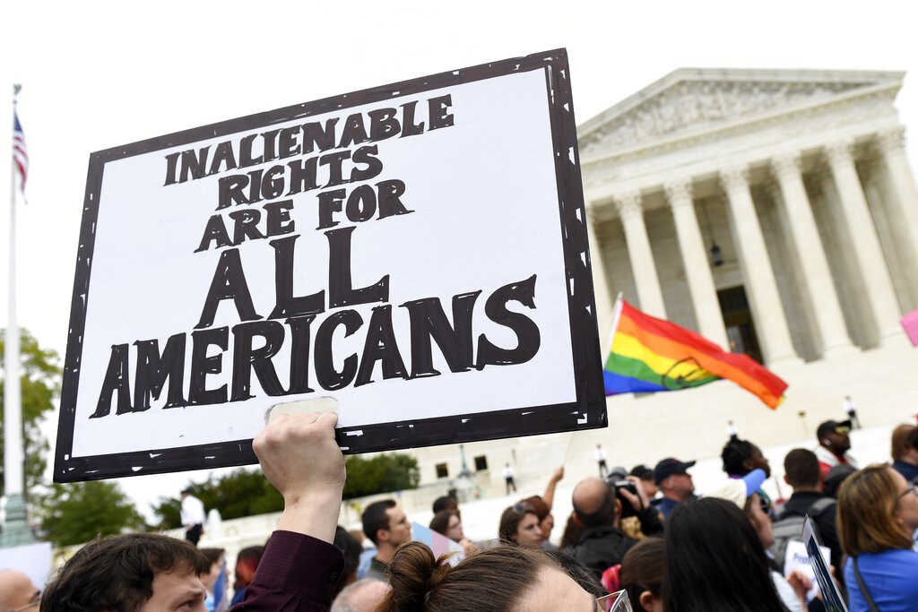 In this Oct. 8, 2019, file photo, protesters gather outside the Supreme Court in Washington where the Supreme Court is hearing arguments in the first case of LGBT rights since the retirement of Supreme Court Justice Anthony Kennedy. (AP Photo/Susan Walsh, File)