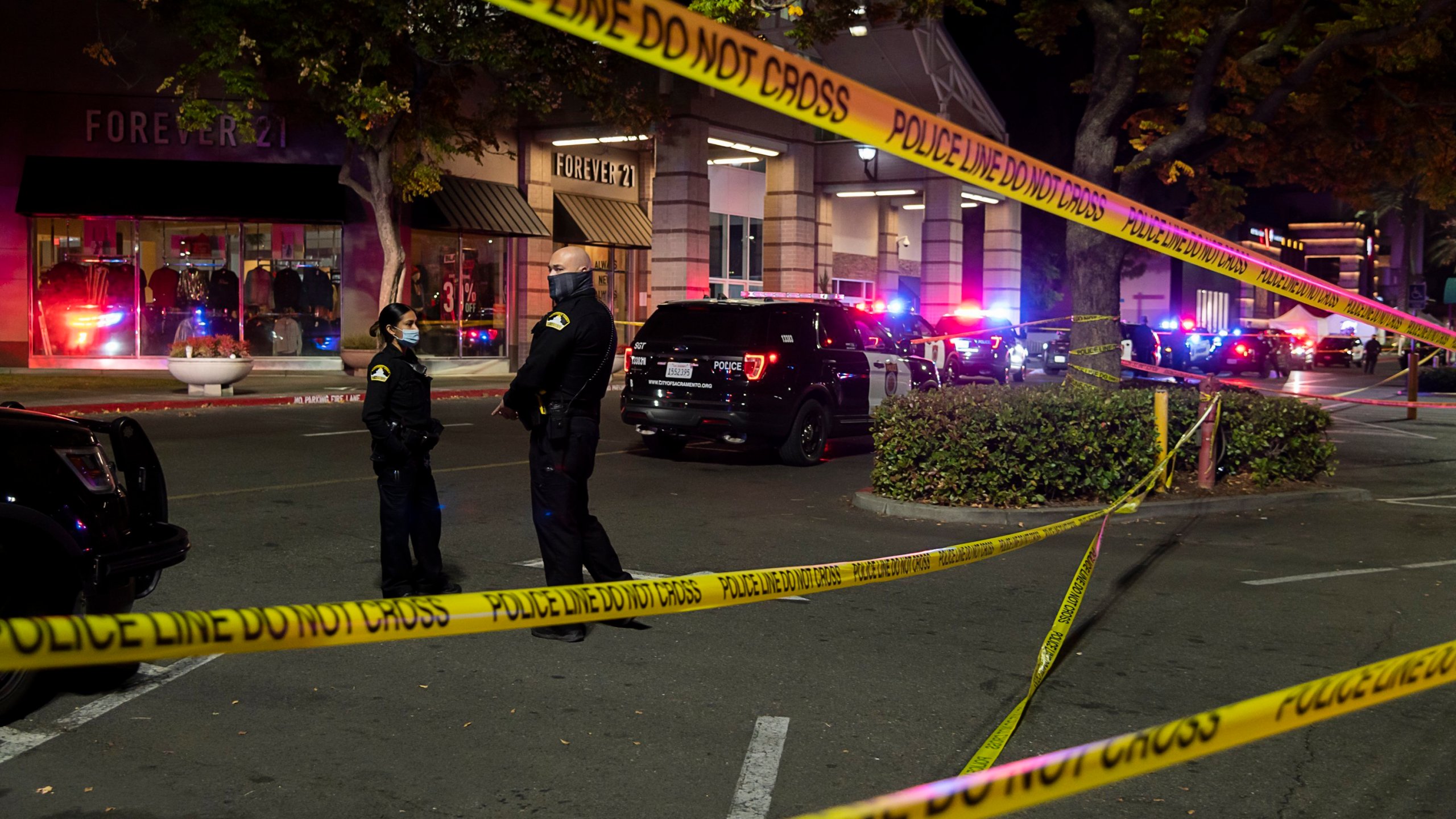 Police stand outside Arden Fair Mall in Sacramento after a shooting that left one person dead and another critically injured on Nov. 27, 2020. (Paul Kitagaki Jr. / The Sacramento Bee via Associated Press)