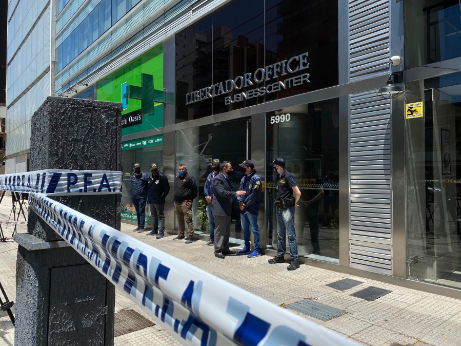 Police guard the entrance to Dr. Leopoldo Luque's practice in Buenos Aires, Argentina, Sunday, Nov. 29, 2020. Luque was Diego Maradona's personal doctor, and his house and offices were raided Sunday in the midst of investigations to establish the circumstances of Maradona's death. (AP Photo/Leo La Valle)