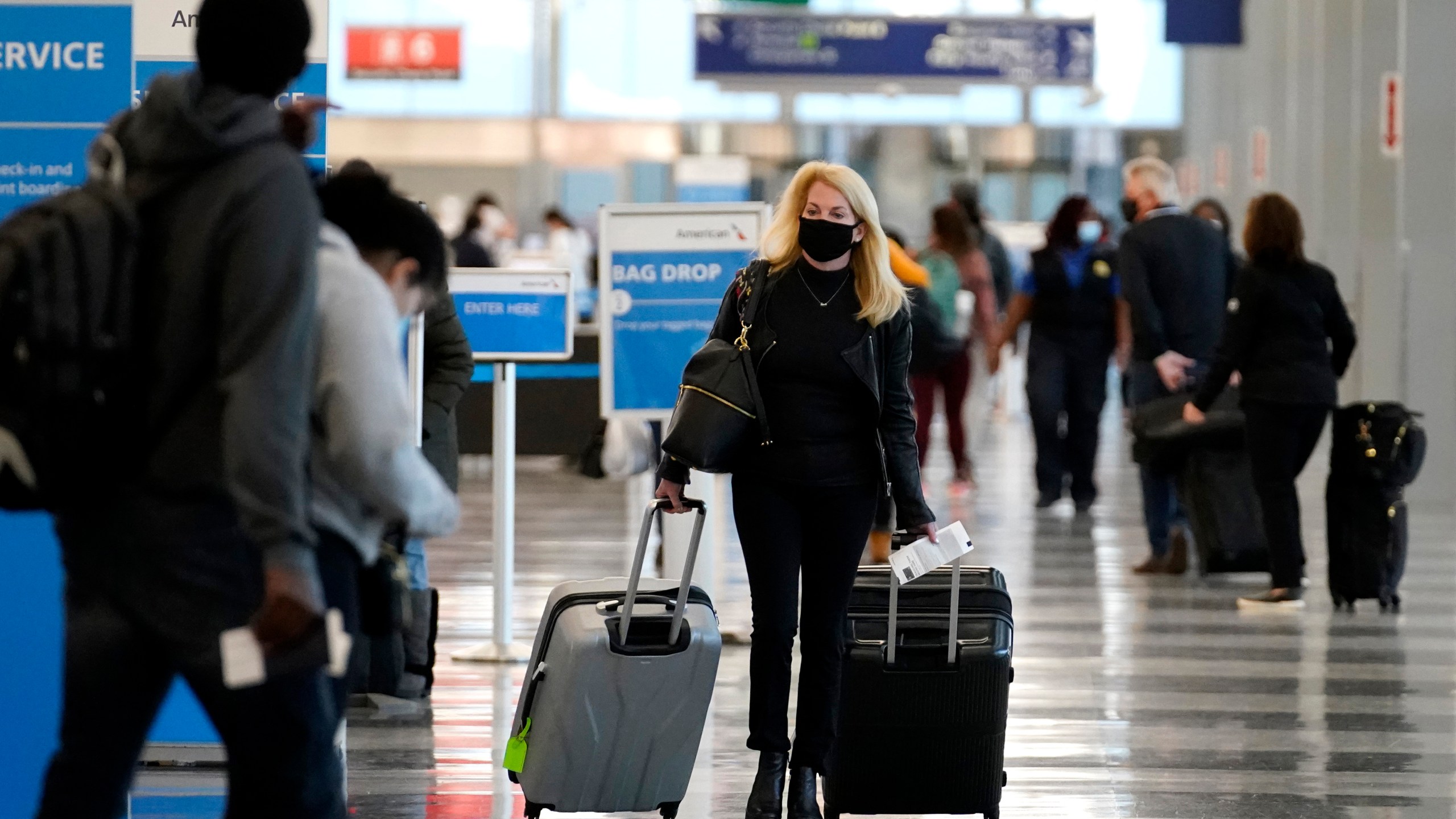 In this Sunday, Nov. 29, 2020 file photo, a traveler wears a mask as she walks through Terminal 3 at O'Hare International Airport in Chicago. (AP Photo/Nam Y. Huh, File)