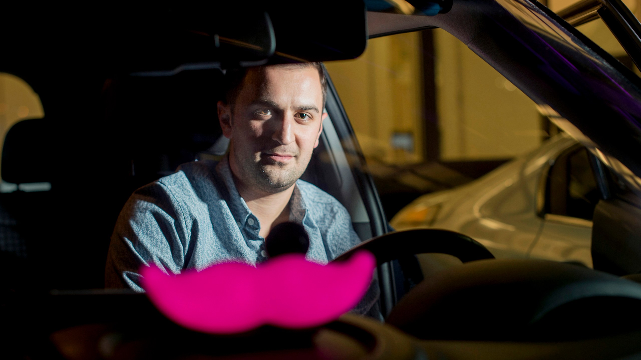 In this Jan. 26, 2015, file photo, Lyft co-founder John Zimmer displays his company's "glowstache" following a launch event in San Francisco. (Noah Berger/Associated Press)