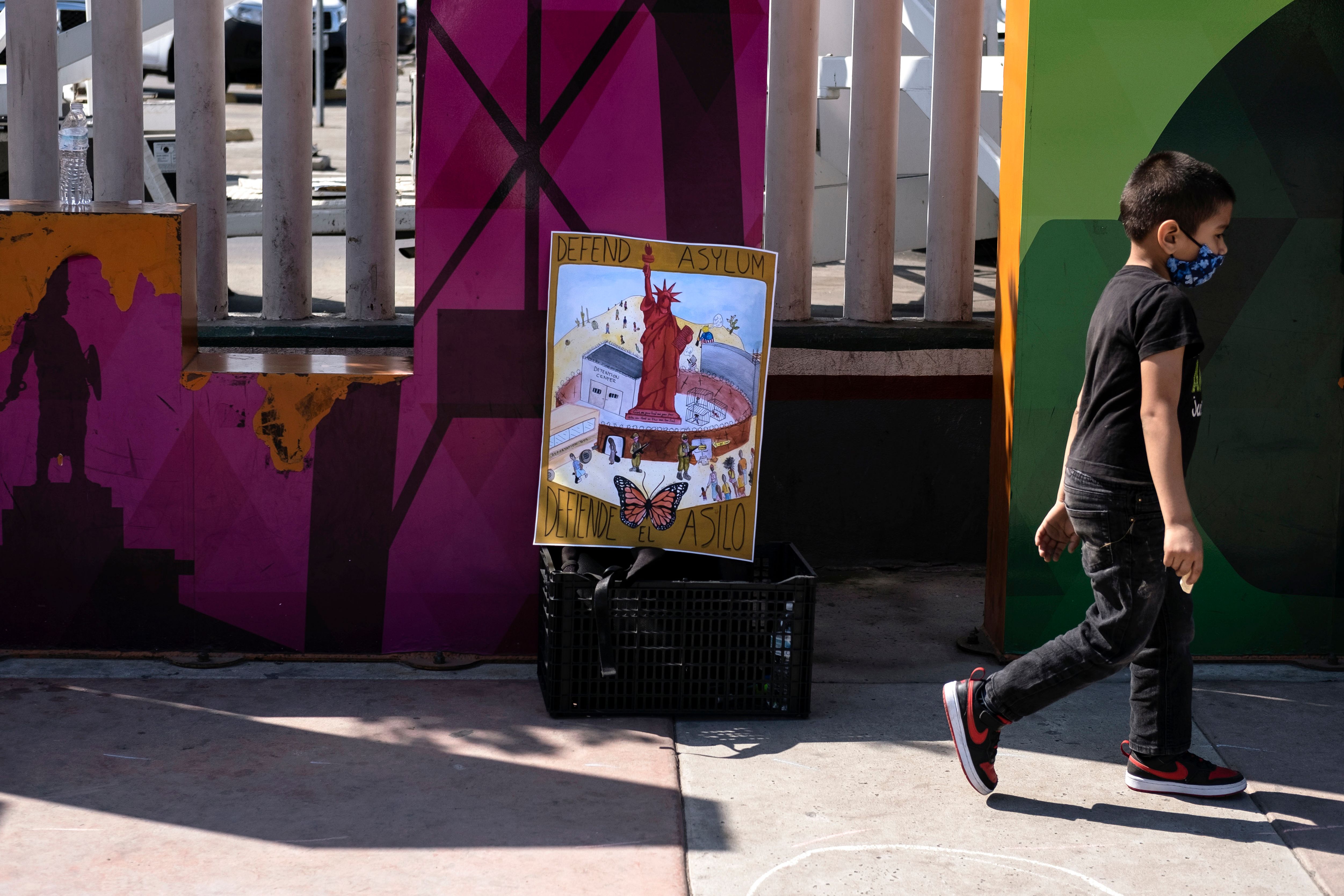 A child takes part in a protest of migrants and human rights activists against U.S. and Mexican migration policies at the San Ysidro crossing port, in Tijuana, Baja California state, Mexico, on the border with the U.S., on Oct. 21, 2020, amid the new coronavirus pandemic. (GUILLERMO ARIAS/AFP via Getty Images)