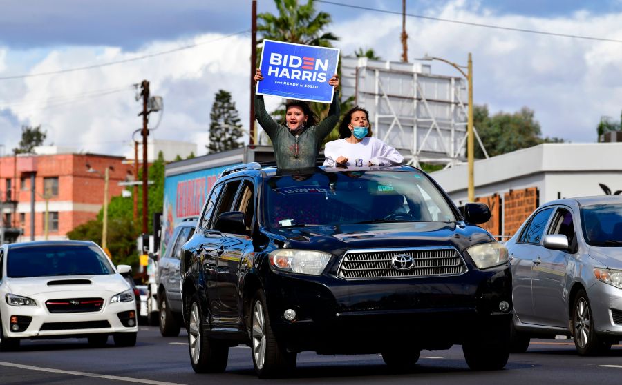 Young supporters cheer from their car holding a Biden-Harris placard as people take to the streets in Los Angeles on Nov.cn 7, 2020 to celebrate Joe Biden and the Democratic Party's victory in the 2020 US presidential elections. (FREDERIC J. BROWN/AFP via Getty Images)