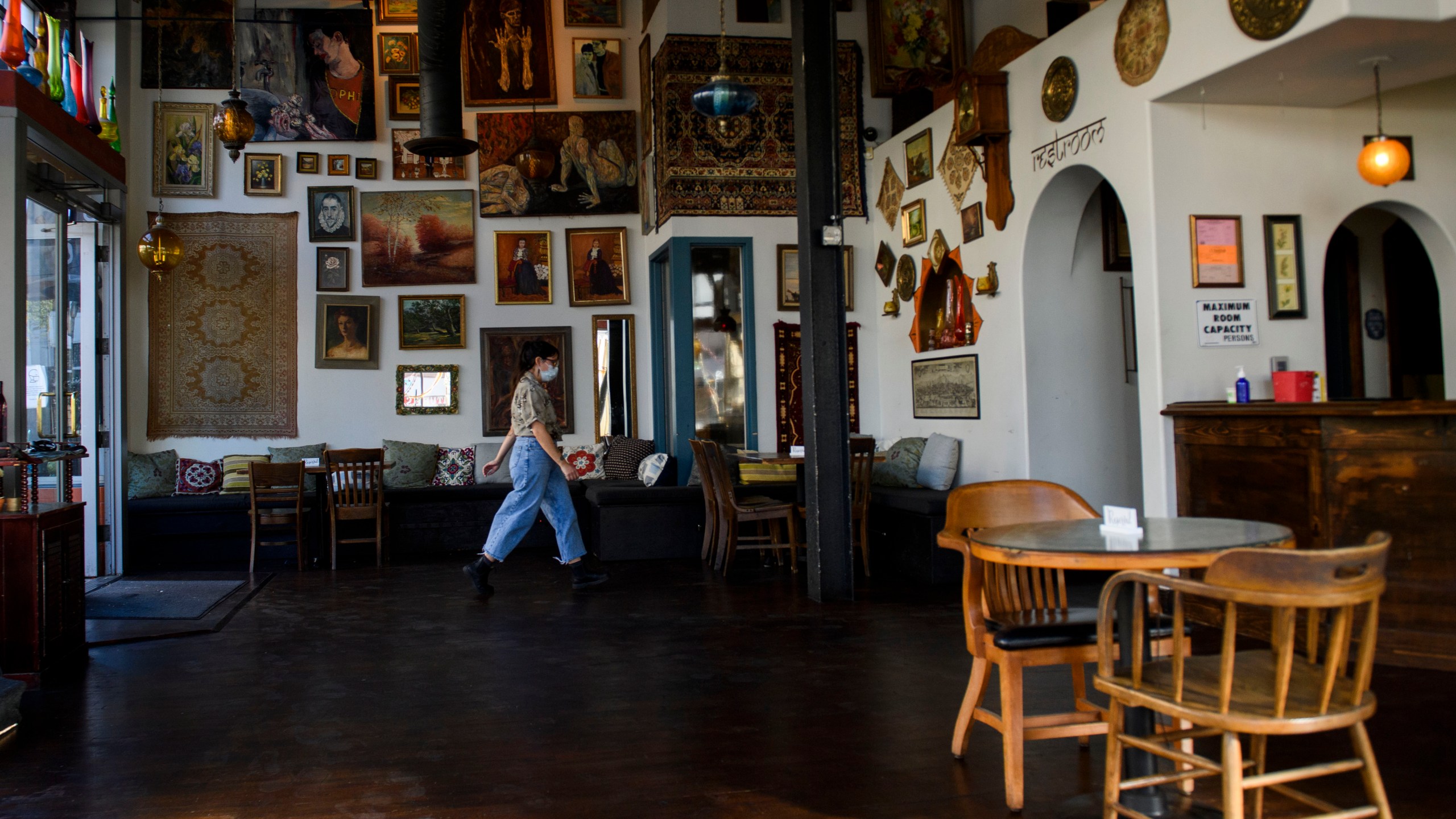 Rachel Thorlund, manager at The Den Cafe, walks past a closed table following reimposed restrictions on indoor dining in Orange County due to Covid-19 in Santa Ana, California, November 17, 2020. (Patrick T. Fallon/AFP via Getty Images)