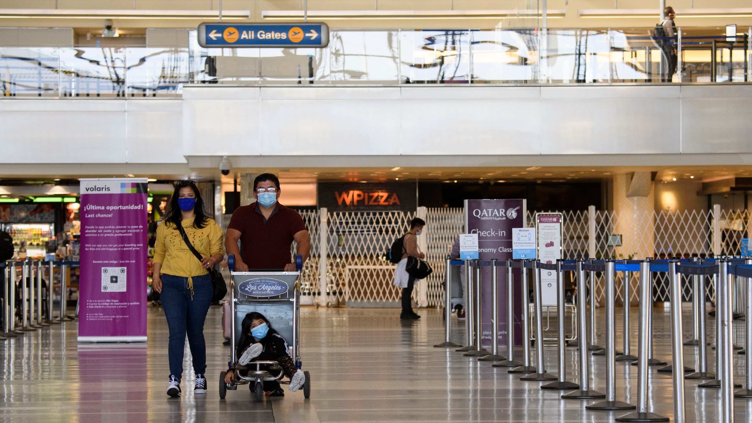 Travelers walk past flight check-in counters inside the Tom Bradley international Terminal at Los Angeles International Airport (LAX) in Los Angeles, California, Nov. 18, 2020. (PATRICK FALLON/AFP via Getty Images)