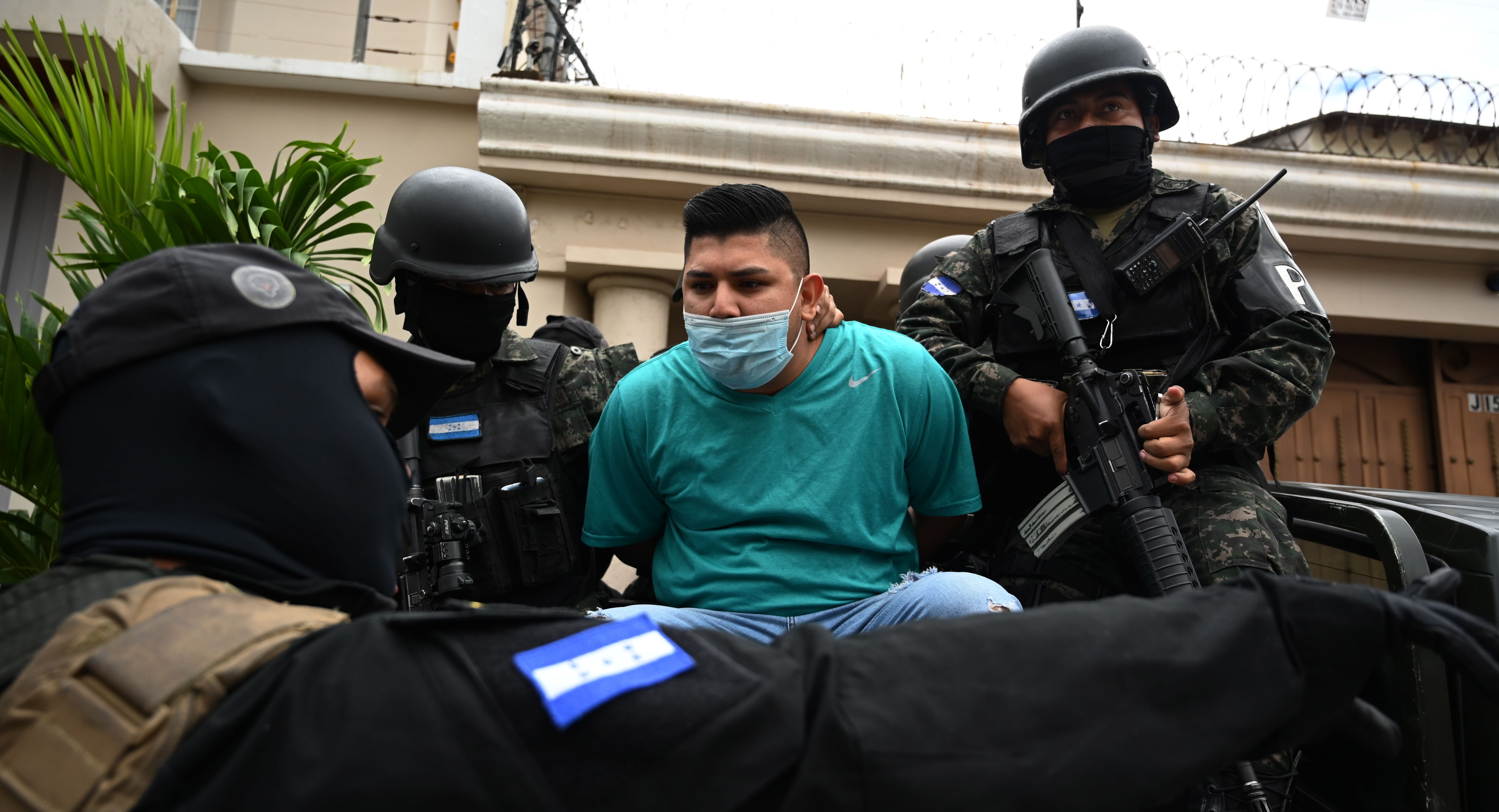 Members of the National Anti Maras and Gangs Force (FNAMP) arrest Jose Alejandro Nunez Cruz (C), alleged administrator of the criminal gang Mara Salvatrucha 13 (MS-13), at an exclusive residential area in Tegucigalpa, on November 26, 2020. (Orlando Sierra/AFP via Getty Images)