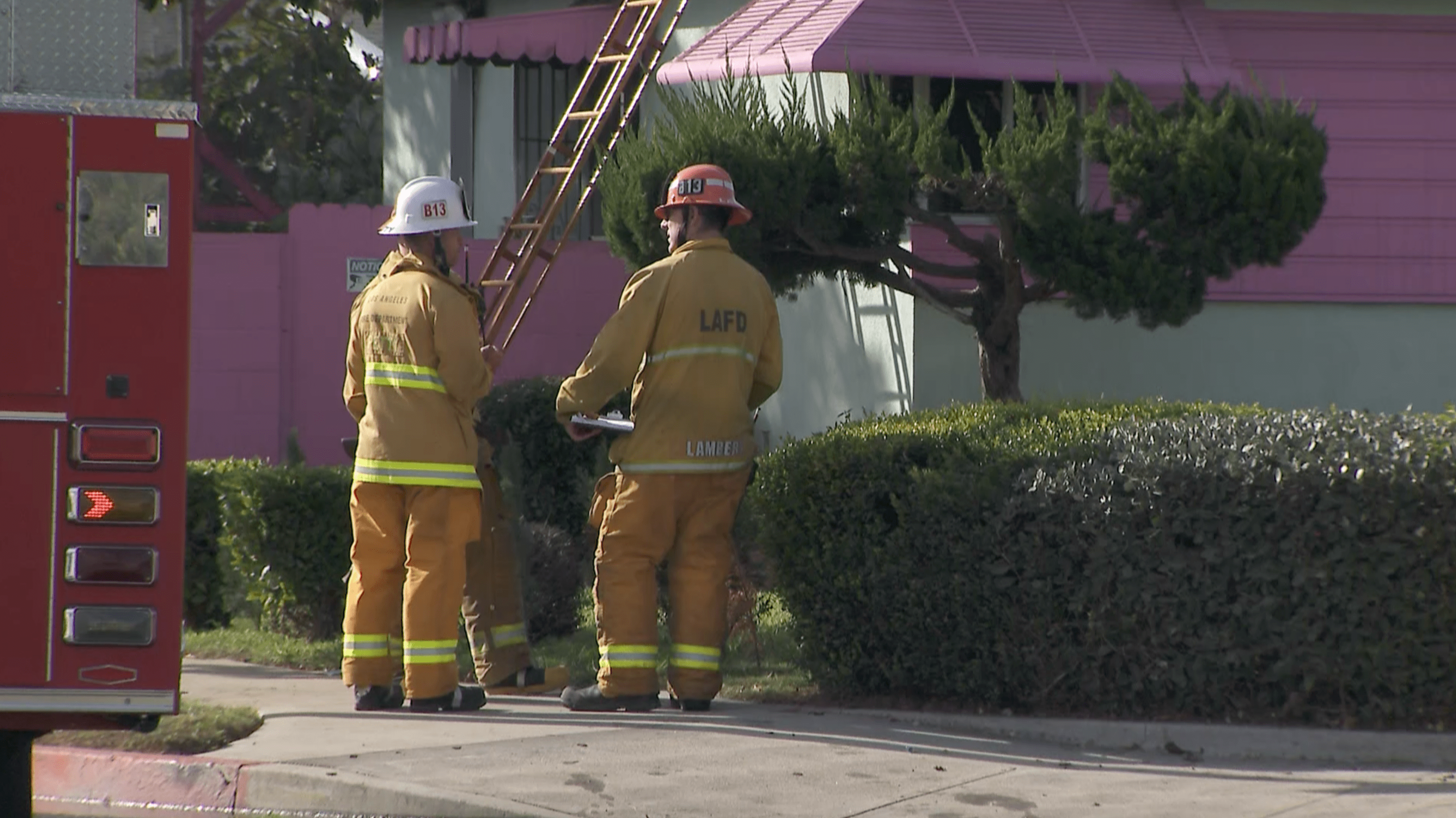 Firefighters stand outside a home after extinguishing a fire that claimed a man's life in Harbor Gateway on Nov. 8, 2020. (KTLA)