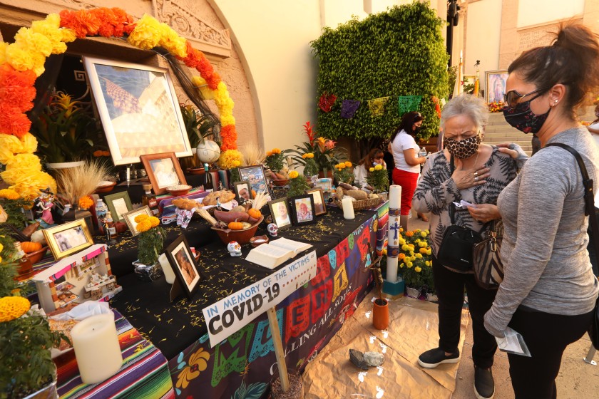 Jessica Peak and her mother, Olivia Altamirano, visit a Día de los Muertos altar at Calvary Cemetery in Los Angeles on Nov. 1, 2020. (Genaro Molina/Los Angeles Times)