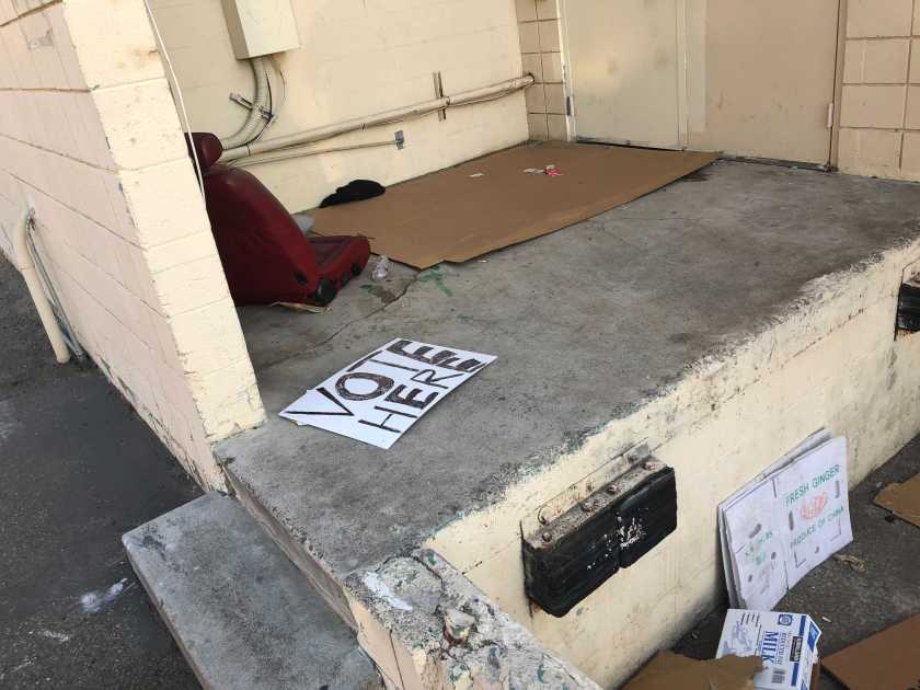 A “voting center” sign discarded behind a building in Westminster is seen on Nov. 3, 2020. (Adam Elmahrek / Los Angeles Times)