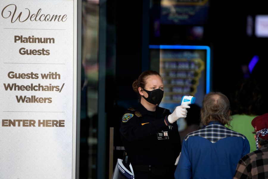 A security official checks the temperature of a man at the entrance to the Viejas Casino and Resort in Alpine, San Diego County, as it reopens on May 18, 2020. (Gregory Bull / Associated Press)