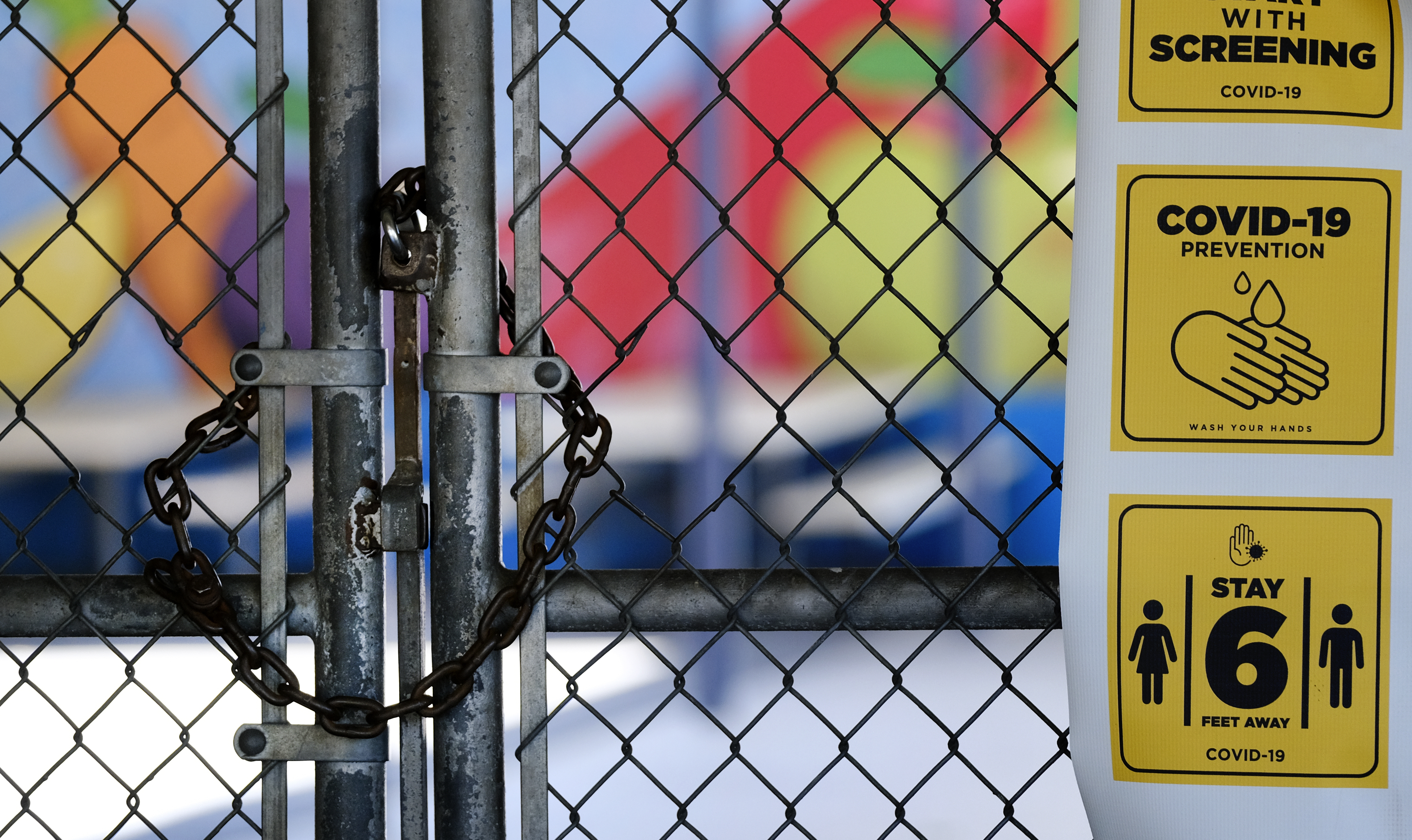 In this July 13, 2020 file photo, a chainlink fence lock is seen on a gate at a closed Ranchito Elementary School in the San Fernando Valley. (AP Photo/Richard Vogel, file)