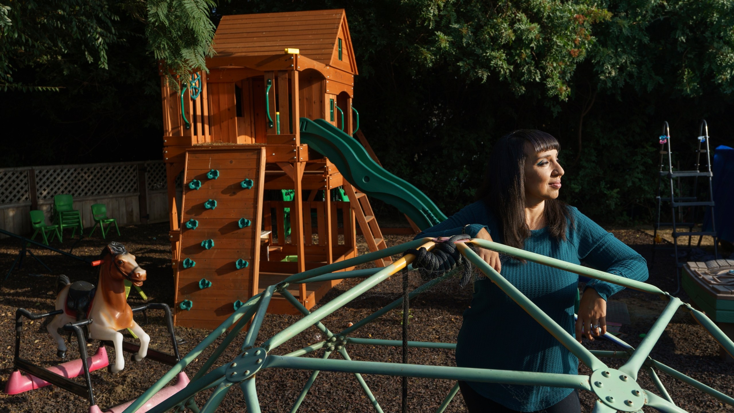 Mary De La Rosa stands inside a play structure in her home backyard, that once housed the now-closed child care program, Creative Explorers, Wednesday, Oct. 21, 2020, in Los Angeles. When De La Rosa closed her toddler and preschool program in March because of the coronavirus pandemic, she fully expected to serve the children again some day. In the end, though, Creative Explorers closed for good. The story of De La Rosa’s program is being repeated across the country as the pandemic’s effects ripple through child care, disproportionately affecting Black and Latino-owned centers in an industry that has long relied on providers of color. (AP Photo/Damian Dovarganes)