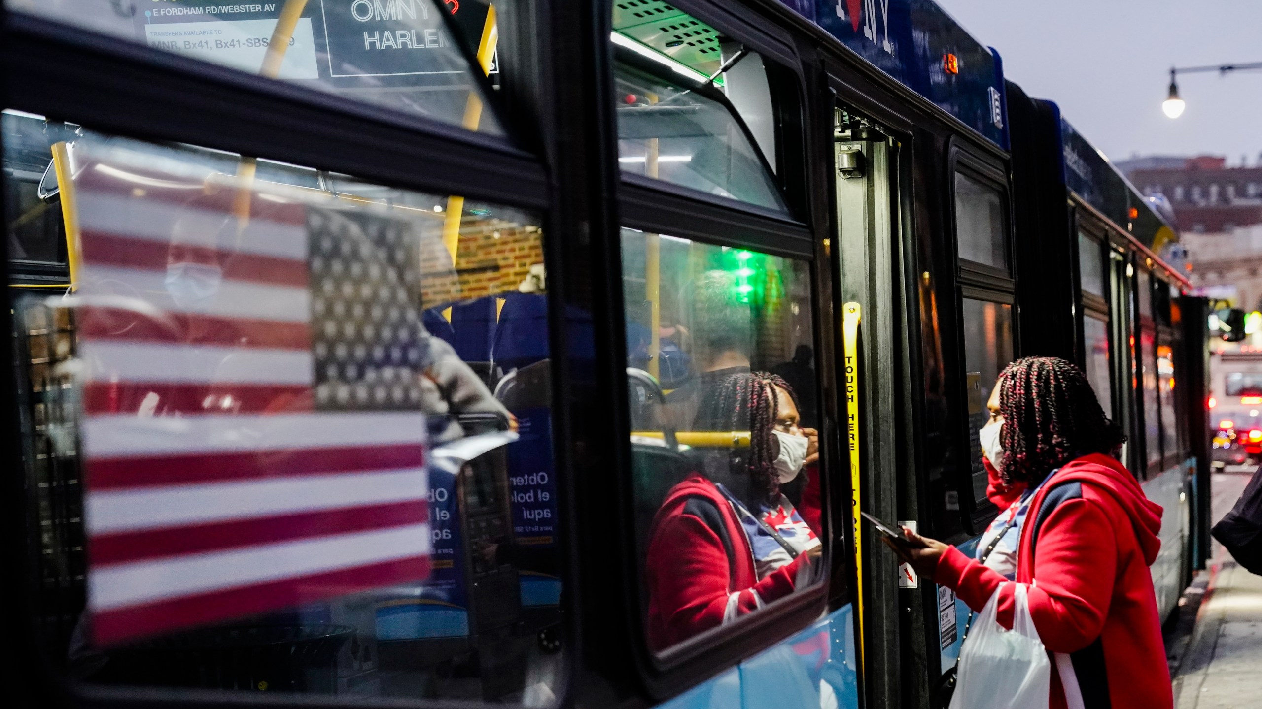 People wear protective masks during the coronavirus pandemic while boarding a bus near the Fordham Metro North station Thursday, Oct. 22, 2020, in New York. (Frank Franklin II/AP Photo)