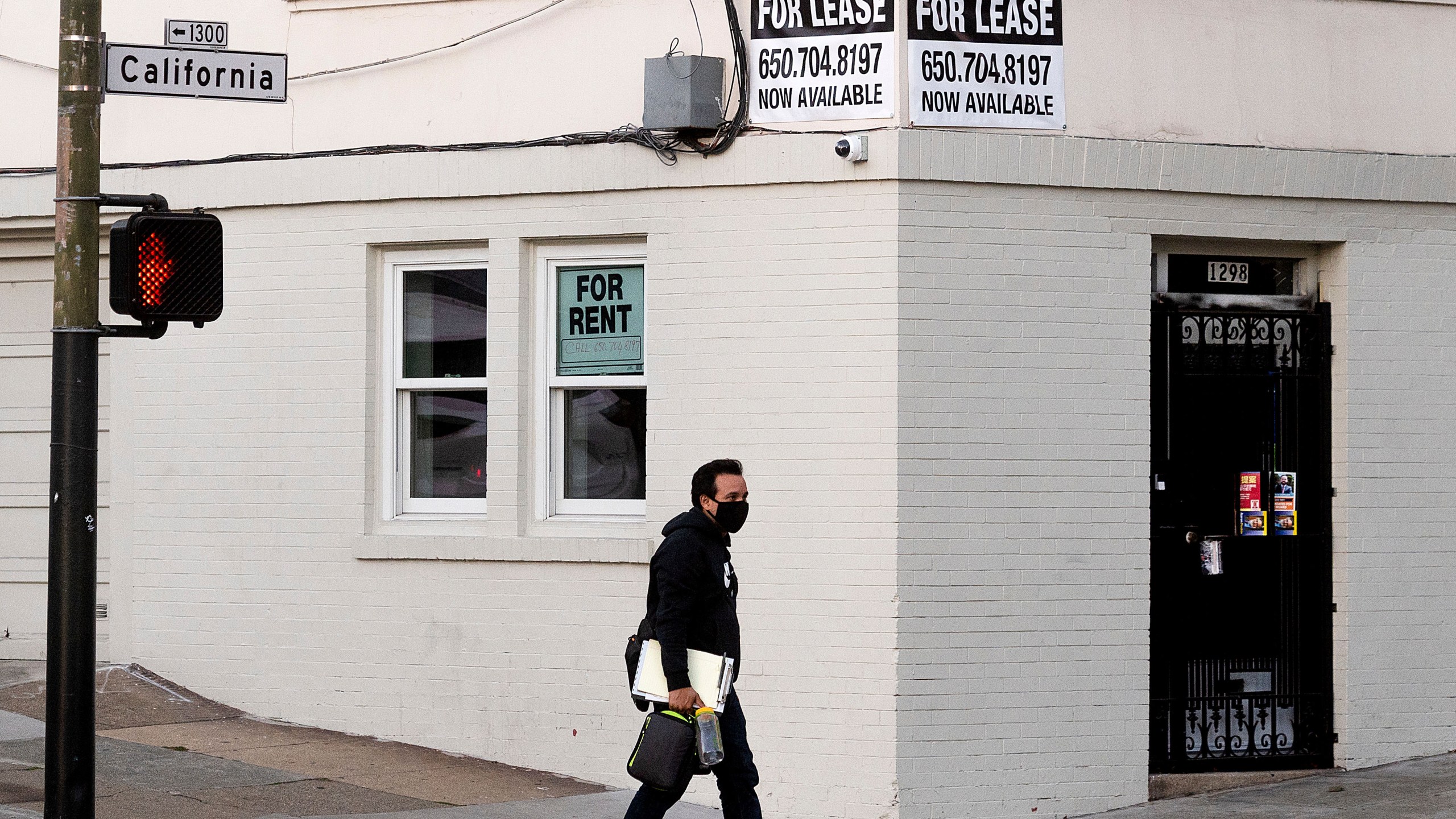 A pedestrian passes under for rent and for lease signs in San Francisco on Oct. 21, 2020. (Noah Berger/Associated Press)