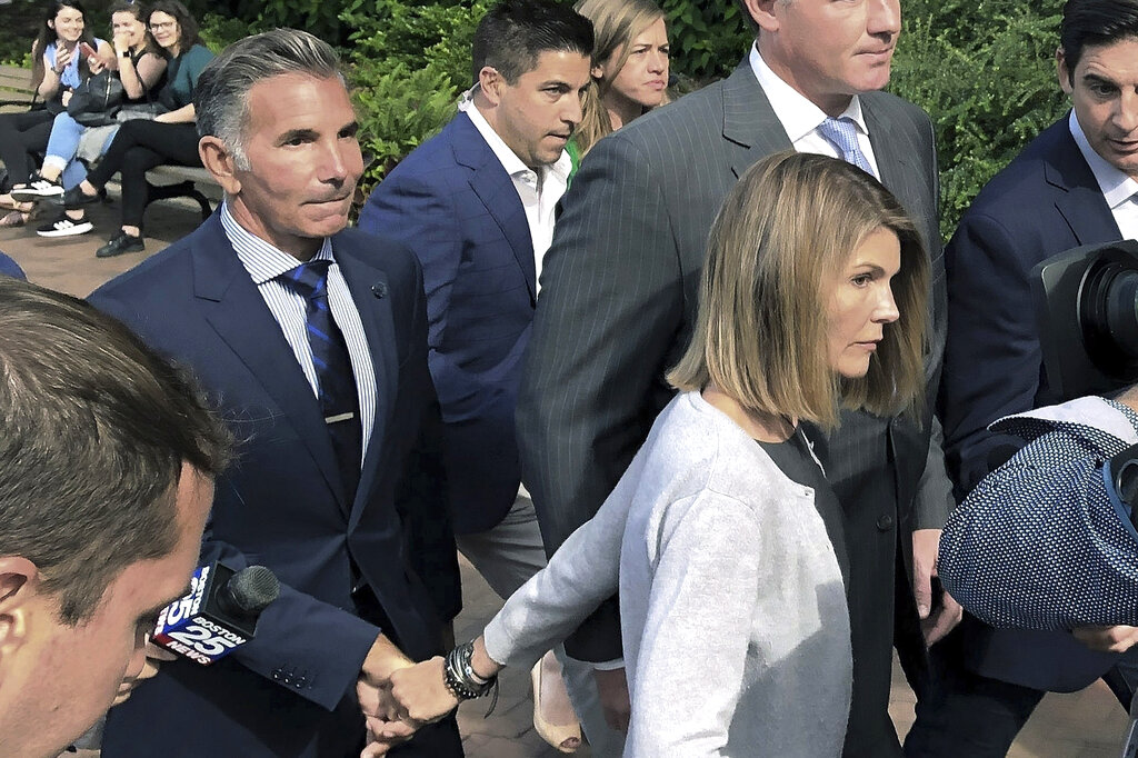 In this Aug. 27, 2019, file photo, Lori Loughlin departs federal court in Boston with her husband, Mossimo Giannulli, left, after a hearing in a nationwide college admissions bribery scandal. (AP Photo/Philip Marcelo, File)